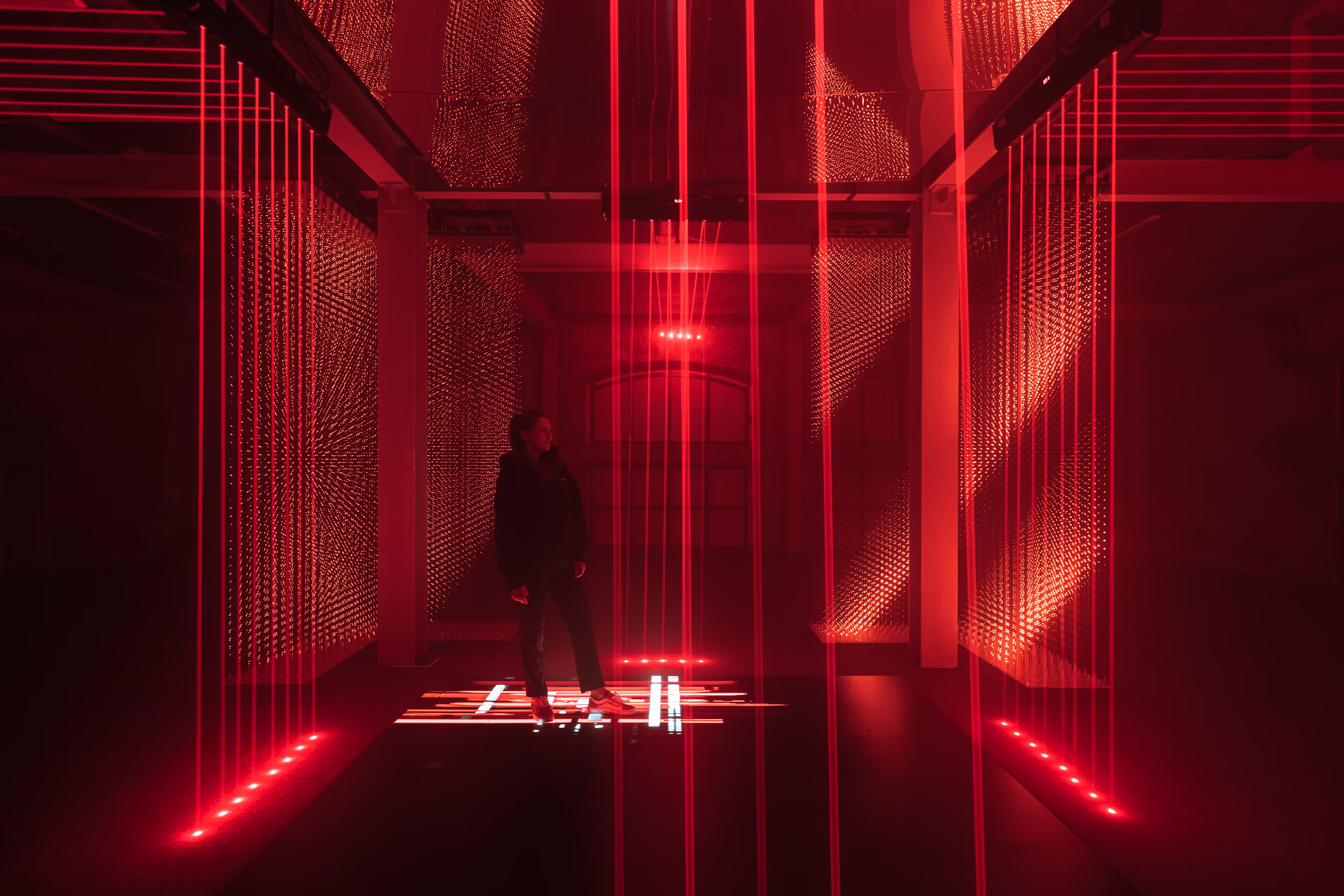 Immersive installation with LEDs, lasers, mirrors, and interactive elements.